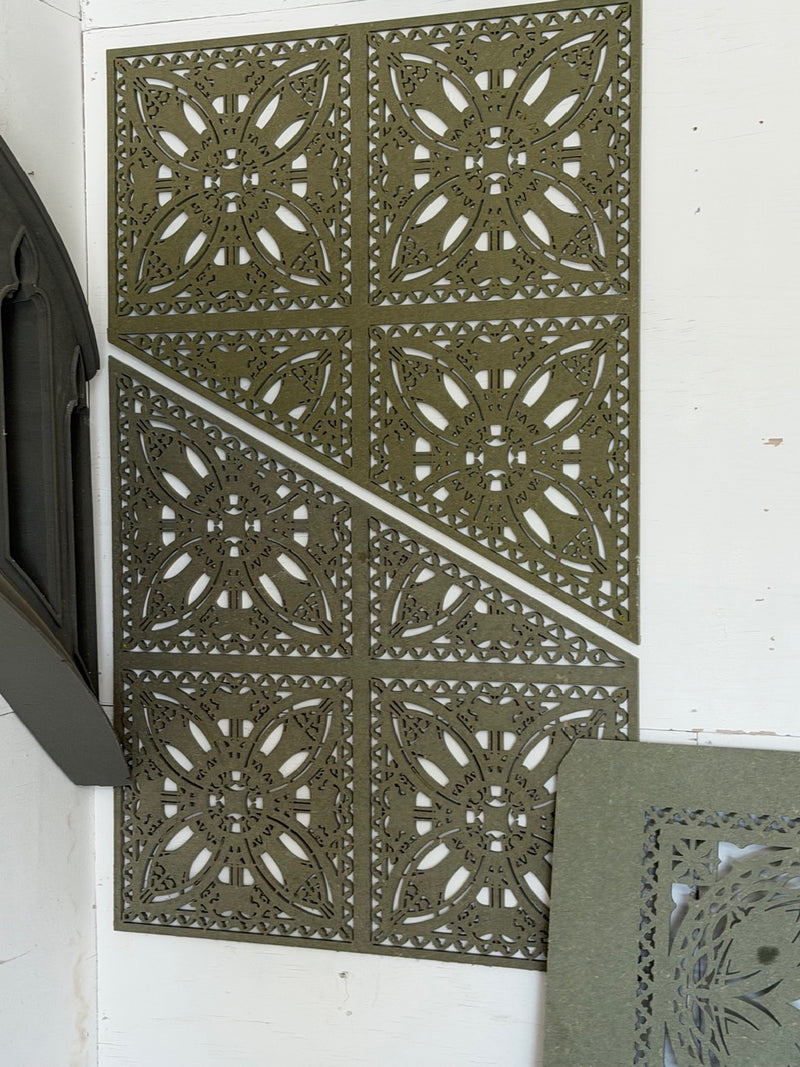 A large decorative cnc-cut mdf wall panel with an intricate geometric and floral mandala pattern, shown in an olive green colour against a white wall.
